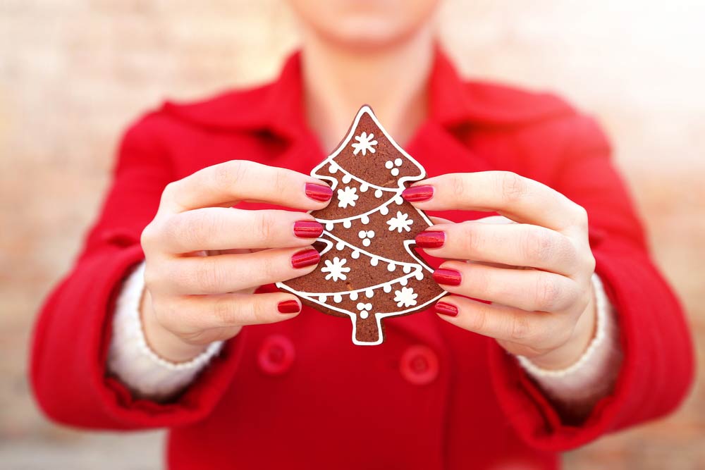 Woman holding up Christmas cookie
