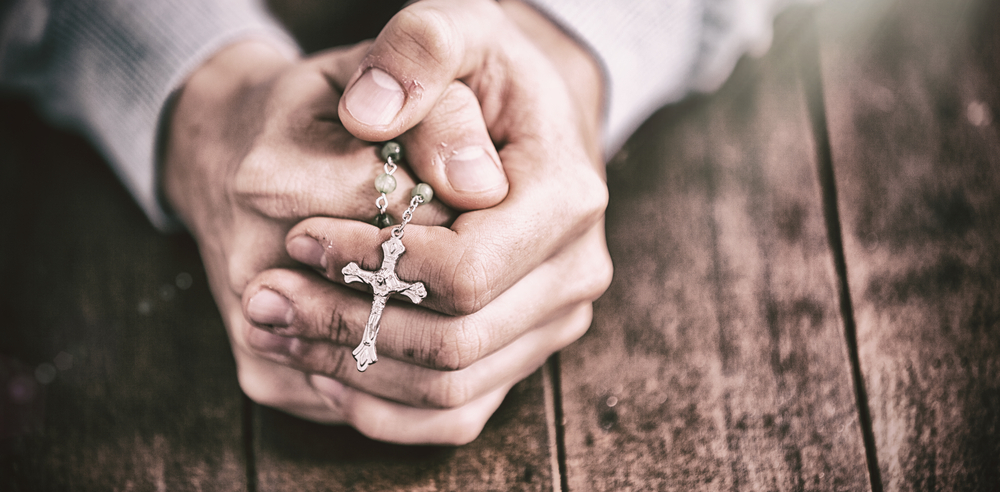 Hands praying rosary