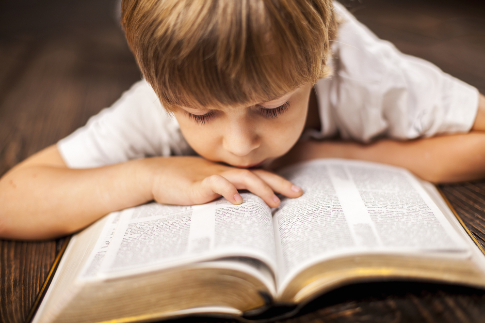 young boy reading the Bible