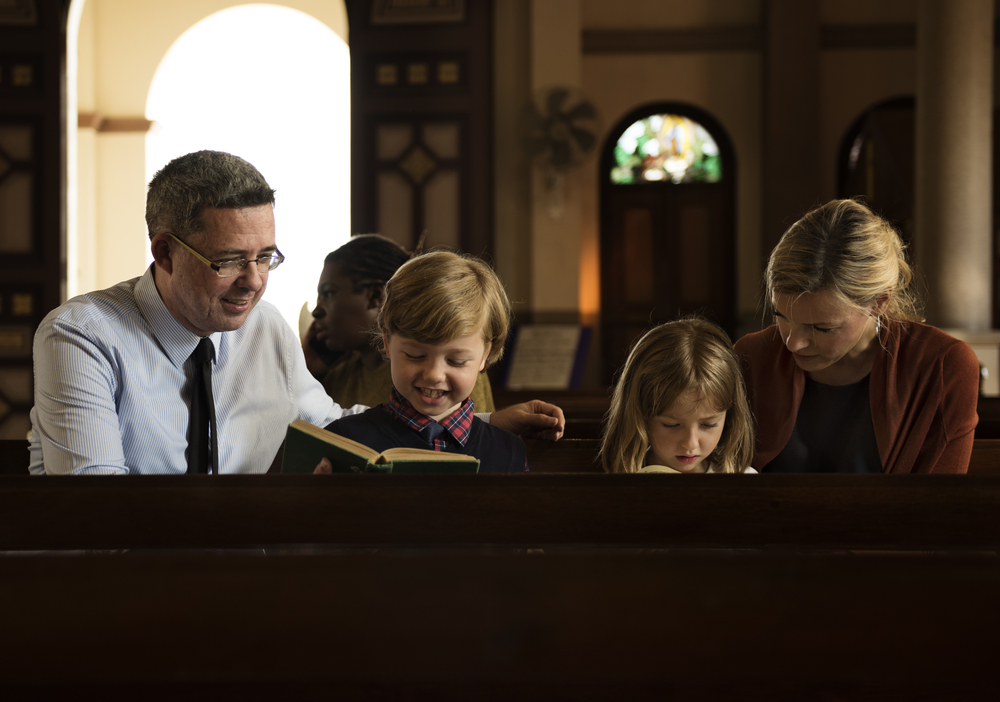 family with two kids in pew at church