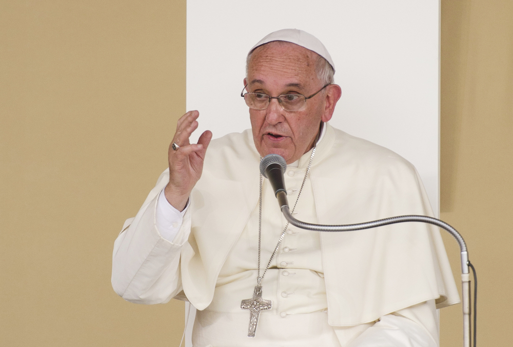 Pope Francis speaks into micrphone