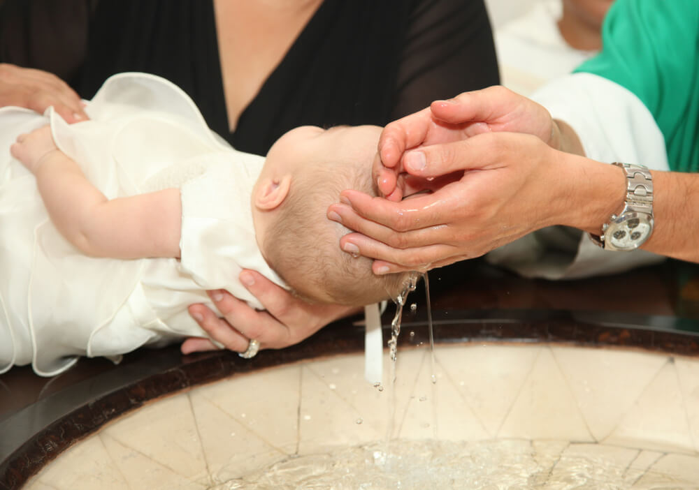infant baptized over Holy Water font