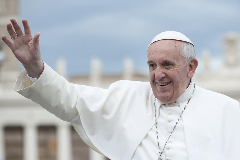 Pope Francis smiles and waves at general audience