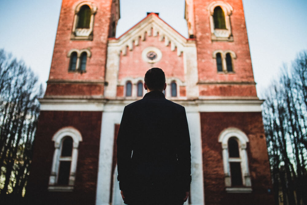 man stands outside church