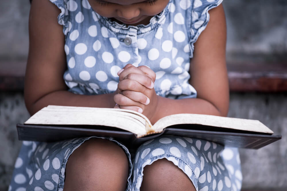 little girl reads Bible