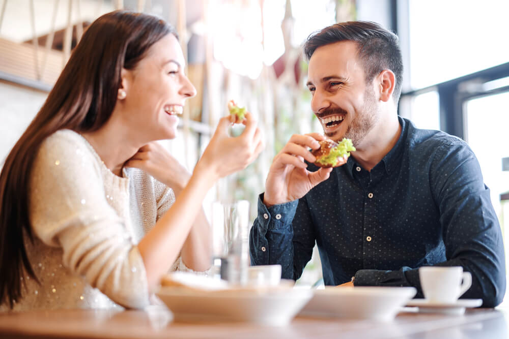 young couple laughs at lunch