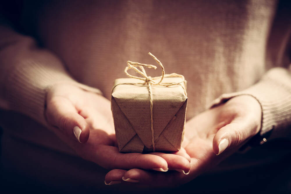 hands reach out with small wrapped gift