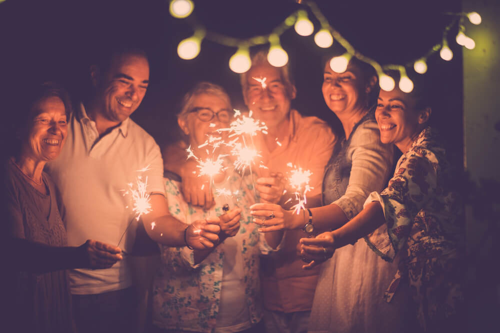 Friends smile with sparklers to ring in the New Year