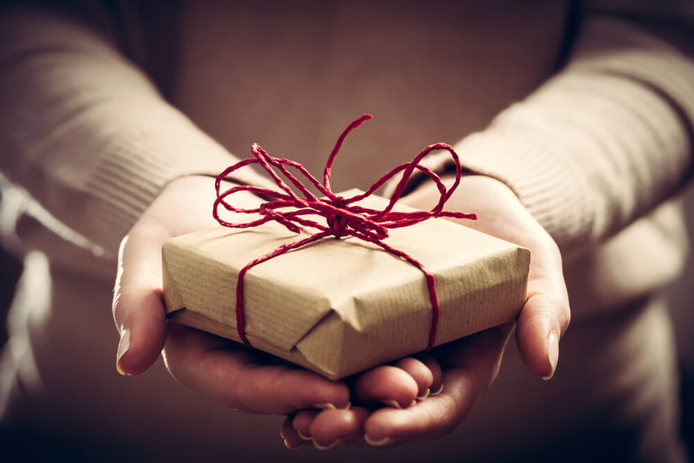 woman offers a wrapped gift