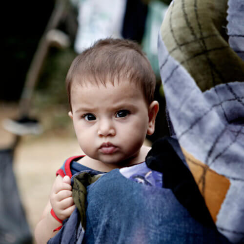 Migrant child held by his mother