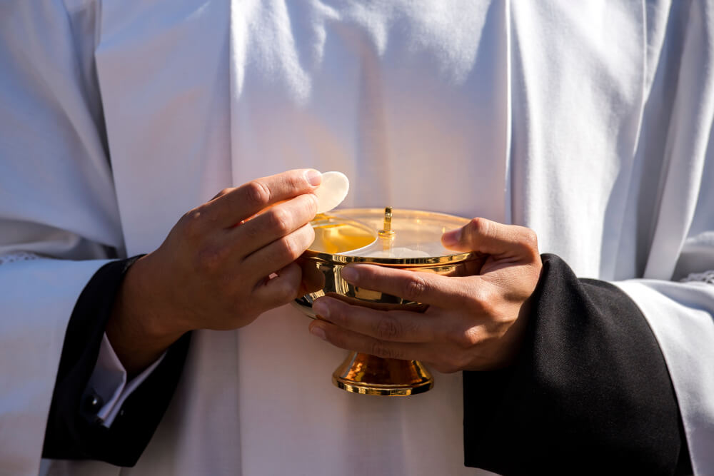 Priest distributes Holy Communion