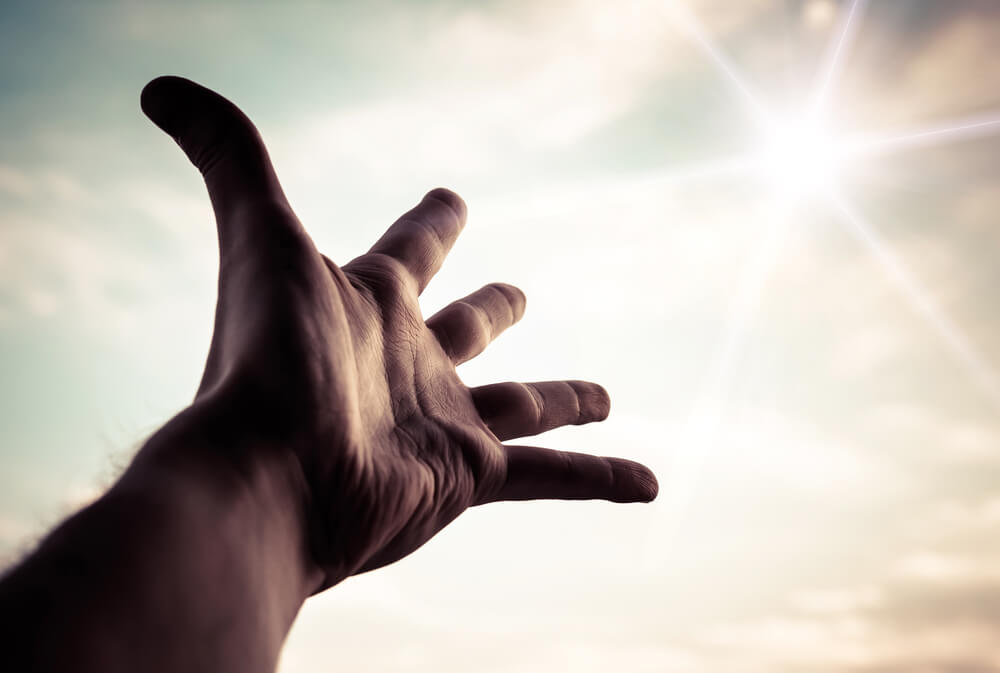 Man's hand reaches to heaven