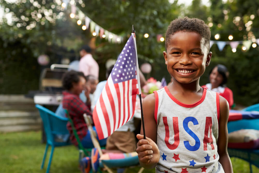 boy holds American flag on 4th of July