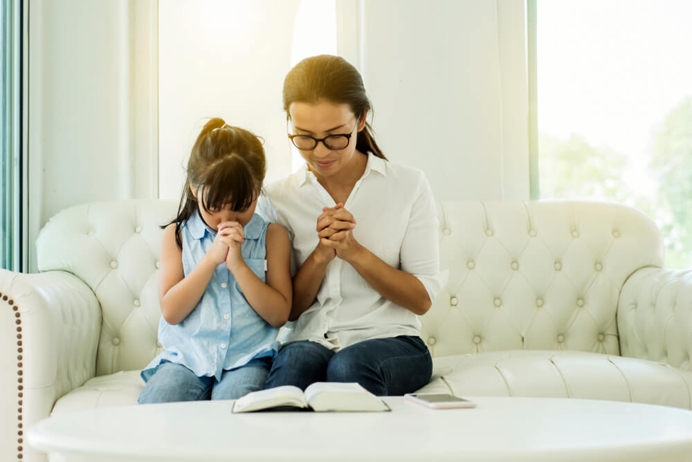Mom prays with daughter