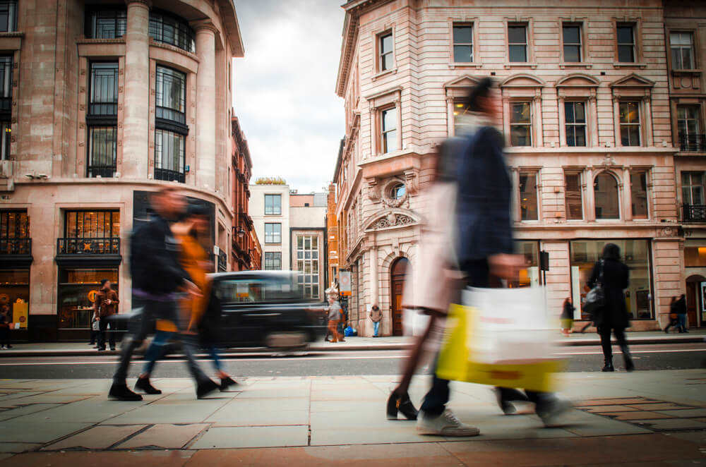 people shop and walk on street in London