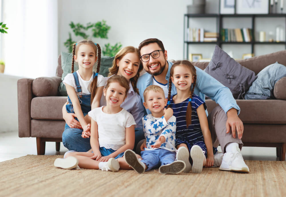 young family of six smiling at home