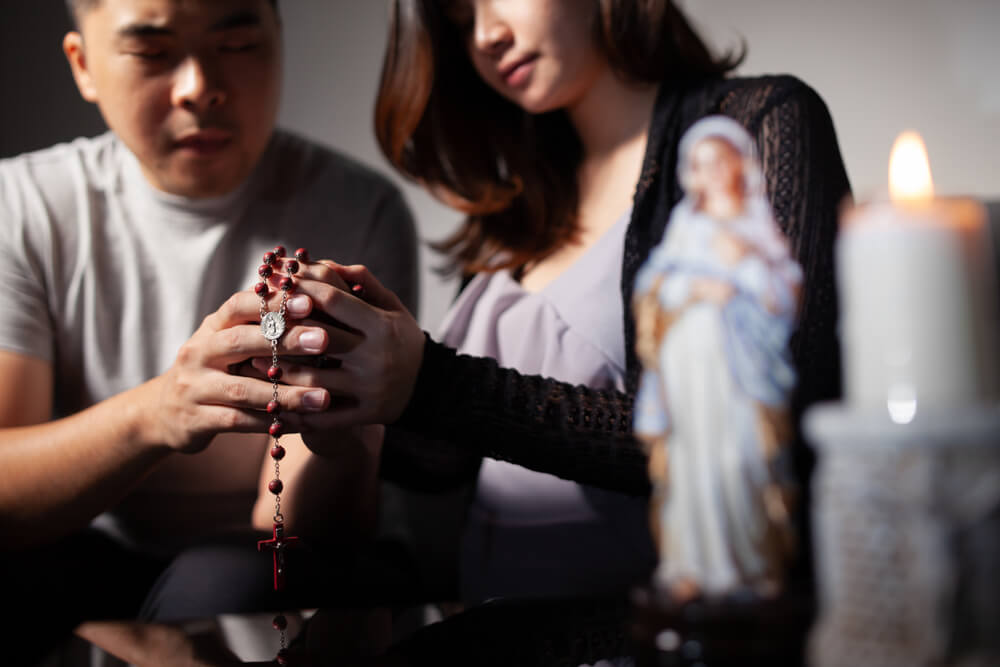 Young couple prays Rosary for baby