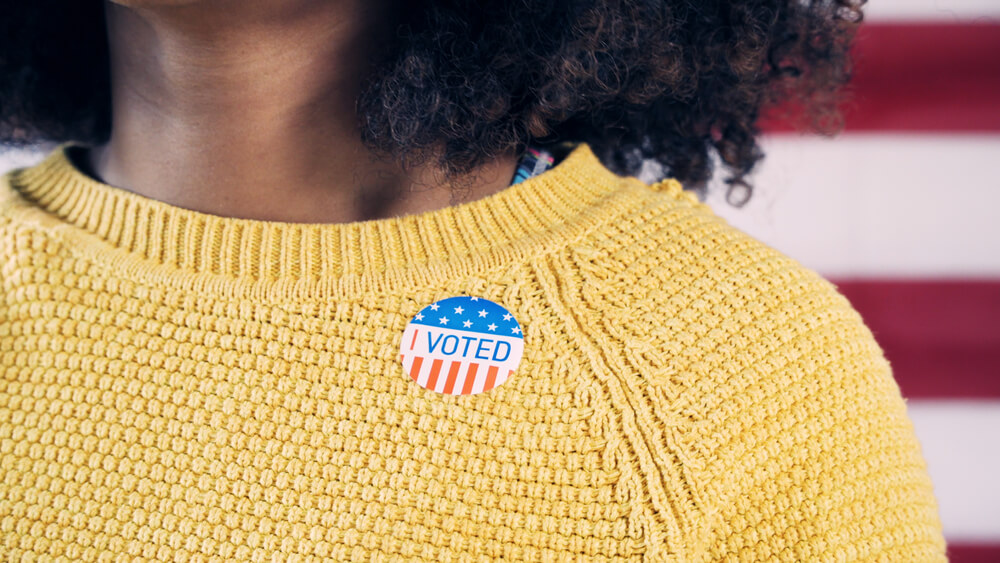 Young woman goes to vote and wears sticker