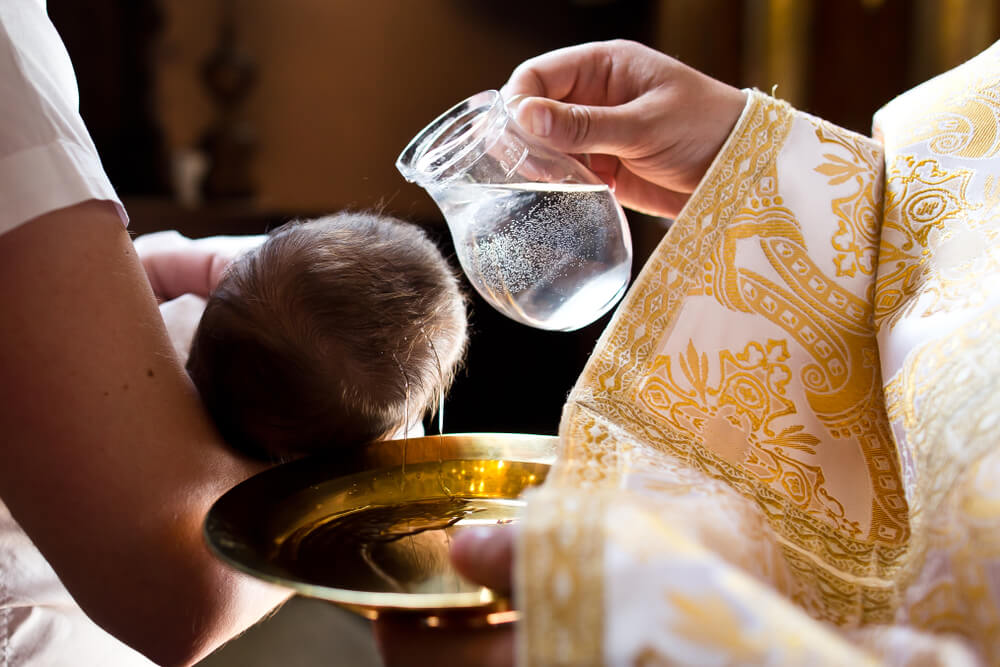 Water poured over baby's head in baptism
