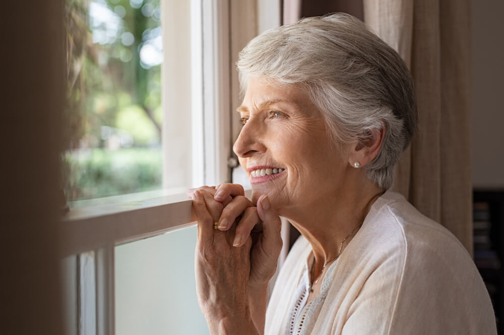 woman at home not lonely, looks happily out window