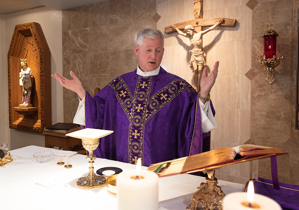 Priest prays at Mass