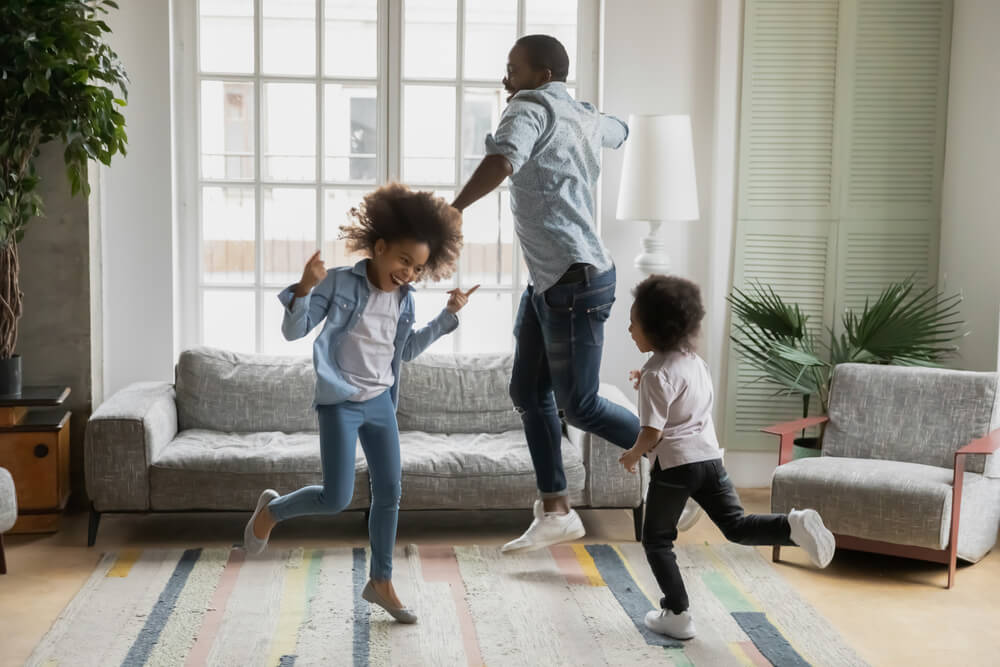 Dad dancing with joy with two of his kids