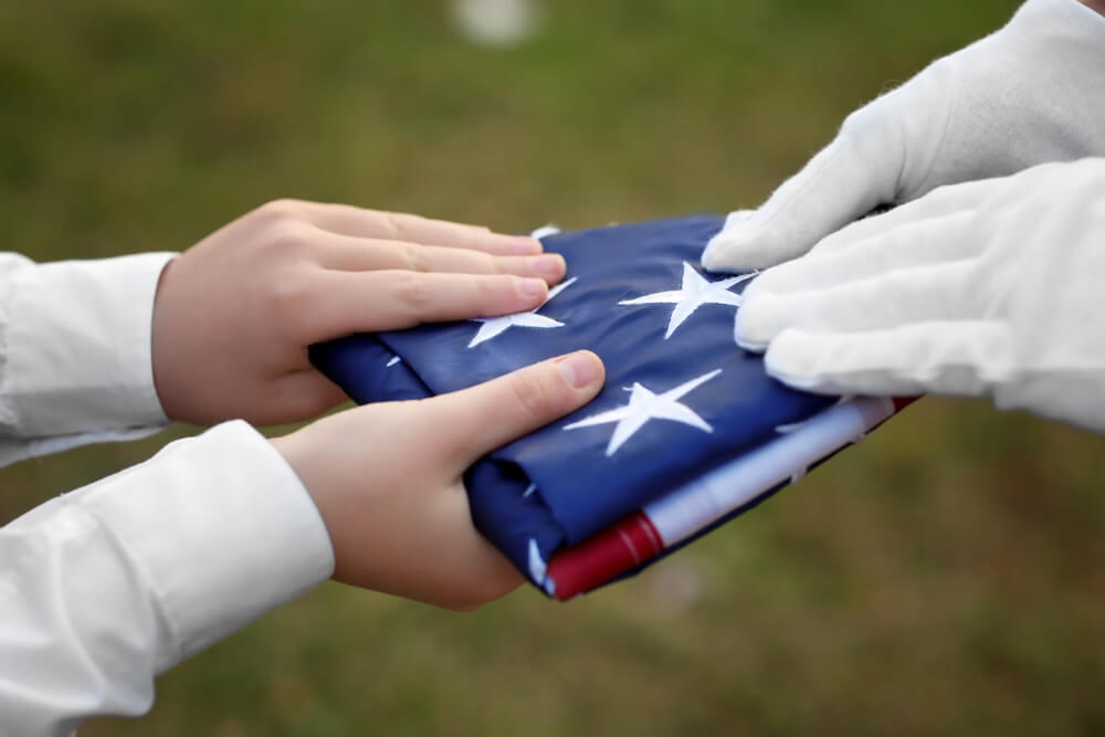 Soldier hands folded flag to loved one