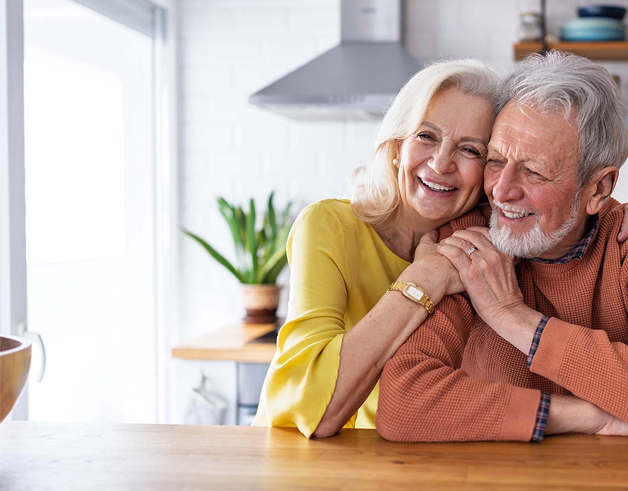 Smiling senior couple embracing in their kitchen